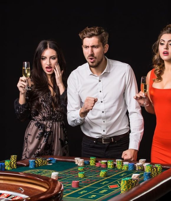 two-young-women-man-roulette-table-black-background-emotions-players